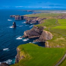 Stunning coastal cliffs and lush green fields with ocean views, inviting tranquil walks and scenic picnics by the sea.