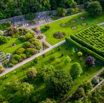 Lush hotel gardens with vibrant maze, manicured lawns, flower beds, and scenic pathways for a peaceful retreat.