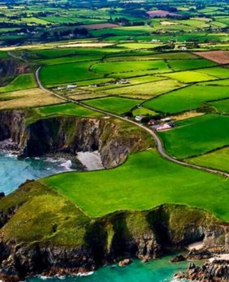 Guests enjoy stunning coastal cliff views, lush green fields, and tranquil blue sea near a scenic countryside hotel.