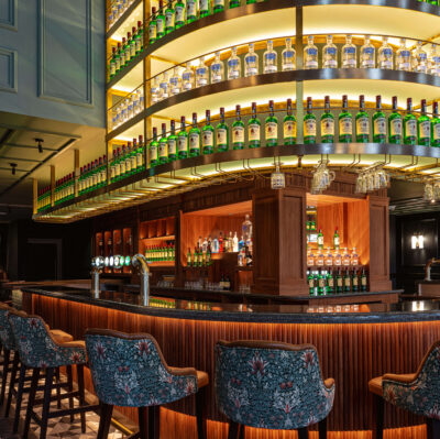 Elegant hotel bar with curved shelves, plush seating, ambient lighting, ideal for relaxing evenings and social gatherings.