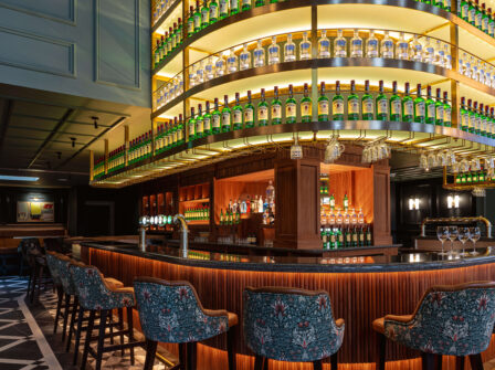 Elegant hotel bar with curved shelves, plush seating, ambient lighting, ideal for relaxing evenings and social gatherings.