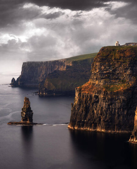 Majestic coastal cliffs with rugged rock formations and stormy skies creating a dramatic backdrop.