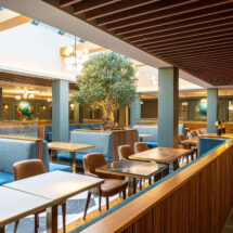 Contemporary hotel dining area with cosy booths, natural light, stylish decor, perfect for guests to enjoy breakfast.