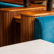 Elegant hotel lounge with plush blue seating, wooden accents, and stylish brass lamps for a luxurious stay.