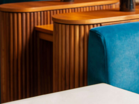 Elegant hotel lounge with plush blue seating, wooden accents, and stylish brass lamps for a luxurious stay.
