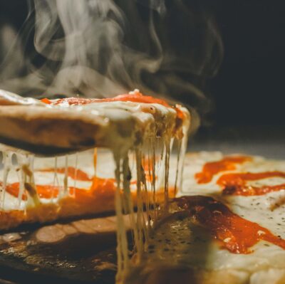 Freshly baked pizza with melting cheese and vibrant tomato sauce, available at our hotel's gourmet restaurant.