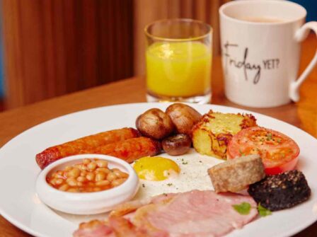 Full English breakfast with bacon, sausage, egg, beans, and juice at luxury hotel restaurant. Inviting and delicious start.