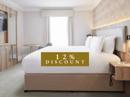 Spacious hotel room with plush king bed, modern decor, flat-screen TV, and elegant wallpaper. Enjoy luxury and comfort.