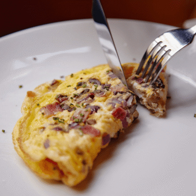 Delicious freshly made omelette with onions in hotel restaurant. Perfect breakfast start with local ingredients.