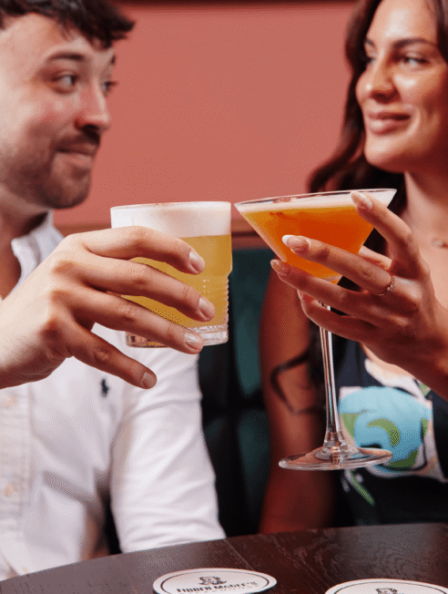 Guests enjoying cocktails in the hotel bar, featuring vibrant decor and a cosy atmosphere.