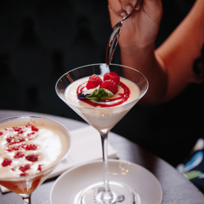 Elegant dessert with fresh raspberries and mint served in a posh hotel restaurant, offering a taste of luxury.