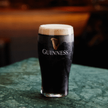 Pint of Guinness on a green marble table in the hotel's cosy pub, perfect for relaxing after a day exploring.
