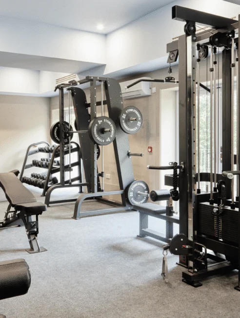 Spacious hotel gym with modern fitness equipment, weight machines, and a relaxing atmosphere for guests' workouts.