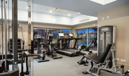 Spacious, modern hotel fitness centre with cardio machines and weights for guest wellness.