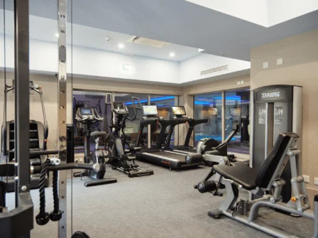 Spacious, modern hotel fitness centre with cardio machines and weights for guest wellness.