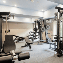 Modern hotel gym with weight machines and equipment; bright and welcoming fitness area for guest workouts.