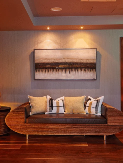 Elegant hotel lounge with cosy sofa, modern artwork, warm lighting, inviting relaxation and comfort.
