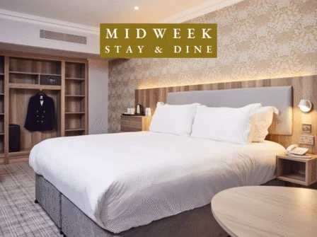 Elegant hotel room with king bed, wardrobe, warm lighting, and tea facilities, perfect for a relaxing midweek stay.