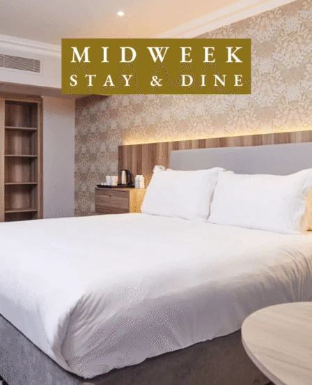 Elegant hotel room with king bed, wardrobe, warm lighting, and tea facilities, perfect for a relaxing midweek stay.