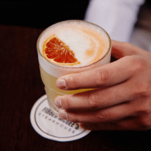 Guest enjoying a refreshing citrus cocktail at hotel bar, featuring elegant surroundings and top-notch service.