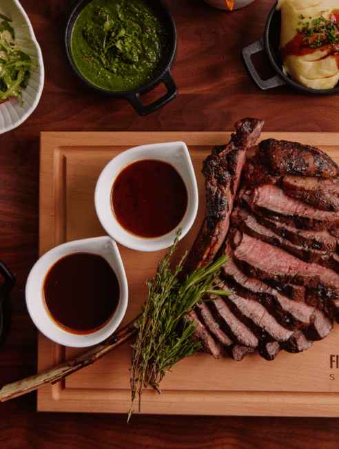 Sizzling steak with sauces at Fibber McGee's Steakhouse, perfect for gourmet dining experience.